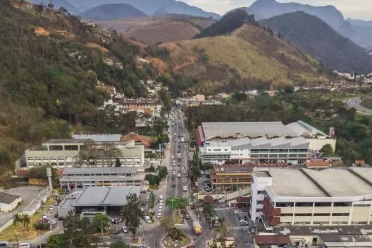 Vista aérea de Itaipava mostrando área central, com comércio, condomínios e montanhas ao fundo, representando as regiões atendidas pela internet SerraLink.